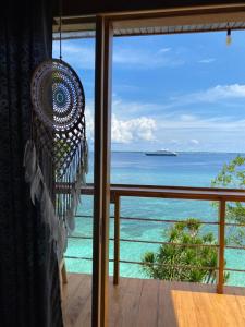 a view of the ocean from a room with a chandelier at Bara Village Guest House Bira in Bira