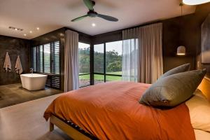 ヤリンガップにあるArtisan Koorabin - Lakeside Luxe Retreat next to Spaのベッドルーム1室(ベッド1台、バスタブ、窓付)