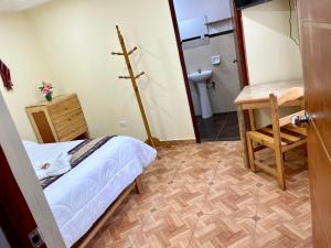 a small room with a bed and a bathroom at TORIBIANS Hotel in Chincheros