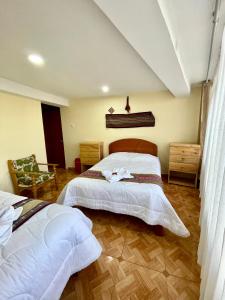 a bedroom with two beds and a chair at TORIBIANS Hotel in Chincheros