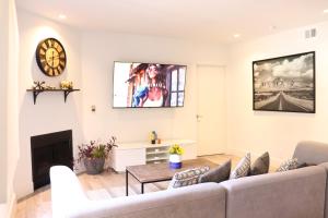 ロサンゼルスにあるHeart Of West hollywood 2 Bedroom 2 Bathのソファと壁掛け時計のあるリビングルーム