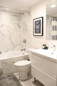 ロサンゼルスにあるHeart Of West hollywood 2 Bedroom 2 Bathのトイレと洗面台を備えた白いバスルーム +9枚の写真