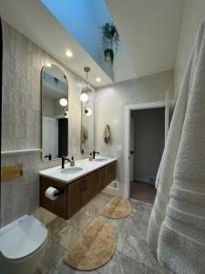 a bathroom with a sink and a toilet and a mirror at European inspired cottage in Spring Lake