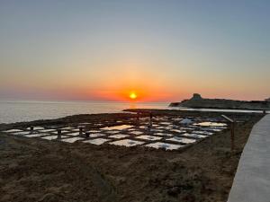 a sunset on the beach with the sun setting at Excellent views in Marsalforn