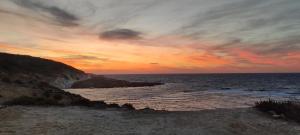 a sunset over the ocean with a rocky beach at Excellent views in Marsalforn