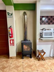 a stove in the corner of a kitchen with a microwave at TORIBIANS Hotel in Chincheros +39 photos