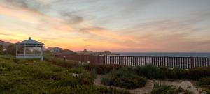a gazebo on the beach with a sunset at Excellent views in Marsalforn