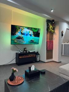 a living room with a large tv on a wall at Ays-SPA, Whirlpool & Sauna in Iserlohn