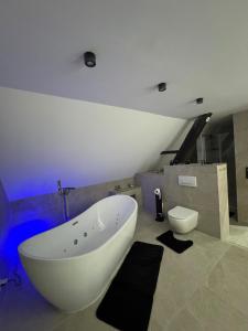 a bathroom with a white bath tub and a toilet at Ays-SPA, Whirlpool & Sauna in Iserlohn +11 photos