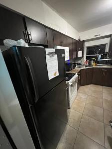 a kitchen with a black refrigerator with a paper on it at Miami Drip Star Life Resort in Parkway Regional Medical Center Heliport