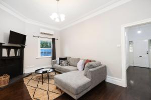 un salon avec un canapé et une table dans l'établissement Modern 3BR Home - 20 Mins to Melbourne CBD, à Maribyrnong
