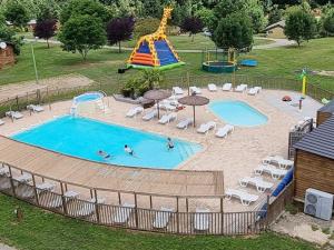 a large swimming pool with a slide and a playground at Chalet cosy - Vue sur l'étang avec terrasse - API-1-52-288 in Naucelle