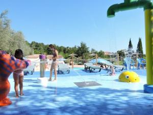 a group of children playing in a water park at Mobil-home cosy 2 chambres en Provence - API-1-52-437 in Venterol