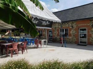 a patio with tables and chairs in front of a building at Mobil home 3 pers avec terrasse à Guégon - API-1-52-624 in Guégon