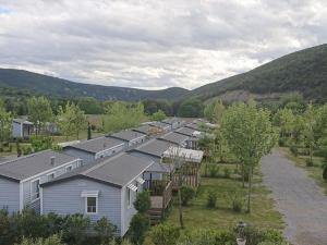 an aerial view of a row of houses with mountains in the background at Mobil-home avec Terrasse pour 6 Personnes en Ardèche - API-1-52-360 in Saint-Maurice-dʼIbie