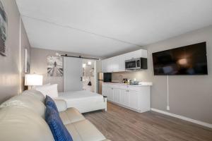 a living room with a bed and a kitchen at Studio, kitchenette, pool & Tiki Bar in Sarasota +77 photos