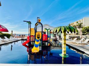 a pool with a water slide at a resort at Solymar Beach Condos in Cancún