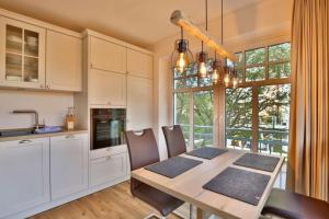 a kitchen with a wooden table and a dining room at Landhaus Lindenhof Turmblick in Wangerooge