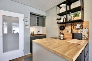 a kitchen with a wooden counter top in a room at Lüttje Bernstein- Gemütlich Stilvoll Zentral in Wangerooge +24 photos