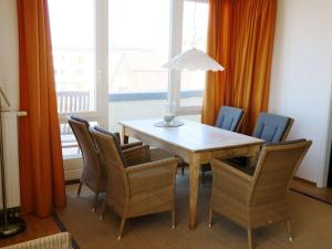 a dining room with a table and chairs and a window at Kaiserhof 302 in Wangerooge