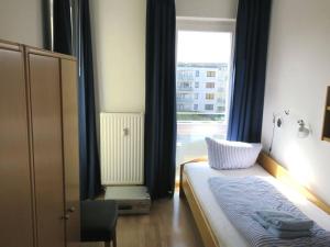 a bedroom with a bed with a window and a chair at Kaiserhof 302 in Wangerooge