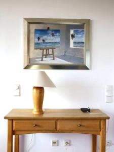 a mirror on a wall above a table with a lamp at Kaiserhof 302 in Wangerooge +9 photos