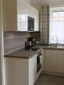 万根沃格Bootshaus Achterstag的厨房里有水槽和炉灶。 上层烤箱