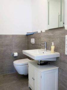 万根沃格Bootshaus Achterstag的带白色水槽和马桶的浴室 更多7张照片