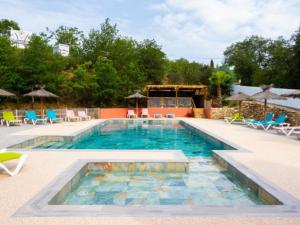 a swimming pool with blue chairs and chairs in it at Mobil-home 33m² avec terrasse au Boulou - API-1-52-398 in Le Boulou +18 photos
