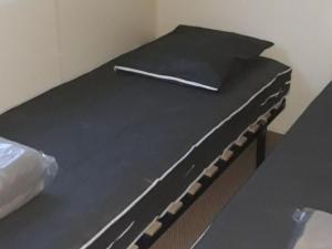a bed with a black sheet and a stick on it at Mobil home 8 pers avec terrasse à Saint-Sornin - API-1-52-461 in Saint-Sornin +21 photos