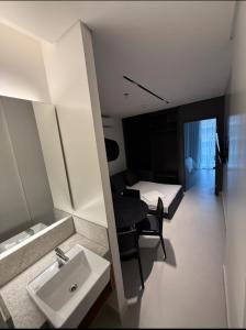 um banheiro com uma pia, uma escrivaninha e uma cama em Porto Alto Resort em Porto de Galinhas