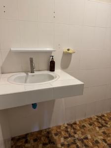 a white sink in a white tiled bathroom at Room with a view Chaloklum in Koh Phangan