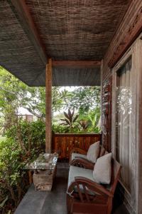 a screened in porch with a bed and a table at Joglo Retreat in Canggu