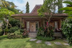 a house with a garden in front of it at Joglo Retreat in Canggu