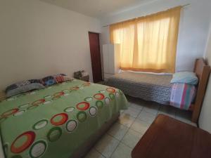 a small bedroom with a bed and a window at Hostal Venecia in Arica