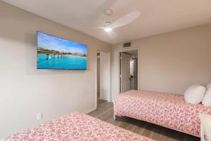 a bedroom with two beds and a tv on the wall at Park Shore Resort Deluxe Condo Top FloorBLDG F 339 in Naples +40 photos