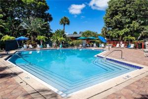 a swimming pool at a resort with chairs and umbrellas at Park Shore Resort Deluxe Condo Top FloorBLDG F 339 in Naples