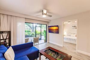 a living room with a blue couch and a table at Park Shore Resort-1st Floor Condo-Park 101 in Naples