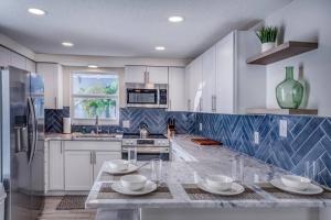 a kitchen with white cabinets and a marble counter top at Restorative Escape-Moonlit Waters-Steps to beach. in Holmes Beach
