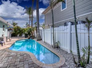 a swimming pool in front of a house with a fence at Tranquility Meets Style-Walk to beach-prvt pool. in Holmes Beach