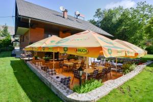 a patio area with tables, chairs and umbrellas at Guest House Bakhus in Žerjavka