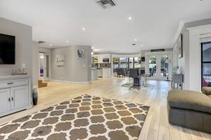 a living room with a couch and a tv at 4BR 6BD Pool HotTub Atlantic Ave in Delray Beach