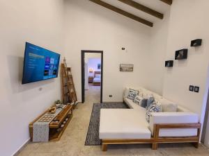Una sala de estar con un sofá y un televisor de pantalla plana. en Jasibe Oceanside in Amatecampo - Steps to beach - Flexible Checkout, en El Porvenir