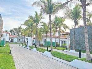 una calle con palmeras frente a las casas en Jasibe Oceanside in Amatecampo - Steps to beach - Flexible Checkout, en El Porvenir