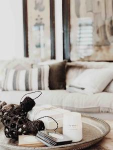 Una mesa con una bandeja con una vela y un plato con una vela. en The Tasman Secret, en Manyana