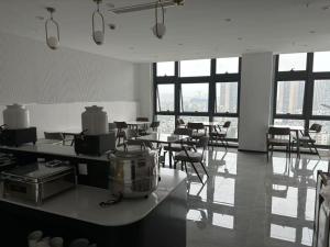 重慶市にあるQinin Hotelのテーブルと椅子と窓のある広い部屋