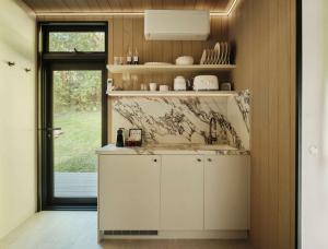 a kitchen with white cabinets and a sink at Luxury Mirror Home In Byron Bay in Byron Bay