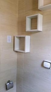 a bathroom with a shower with a cell phone on the wall at Kitnet versátil e acolhedora in Ribeirão Pires