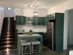 a kitchen with green cabinets and a refrigerator at Ocean view villa in Port Antonio