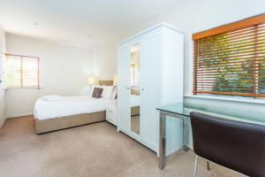 a bedroom with a bed and a desk and a window at Como Mezzanine Retreat in Perth +14 photos